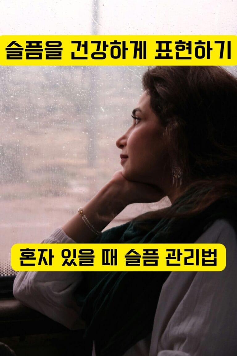 비 오는 창밖을 바라보며 슬픔을 극복하는 여성