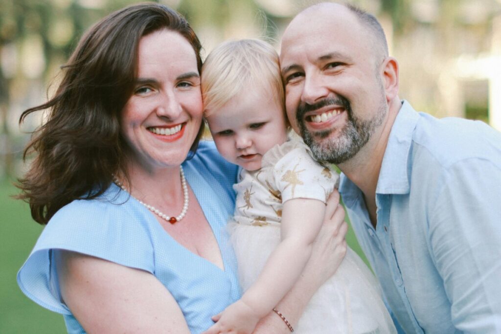 육아기 근로시간 단축 신청 후 집에서 아이를 돌보며 정서적 교감을 나누는 부모-부모가 아이를 따뜻하게 안고 있는 모습으로, 단축 근무를 통해 확보된 시간이 아이에게 주는 안정감을 표현합니다.