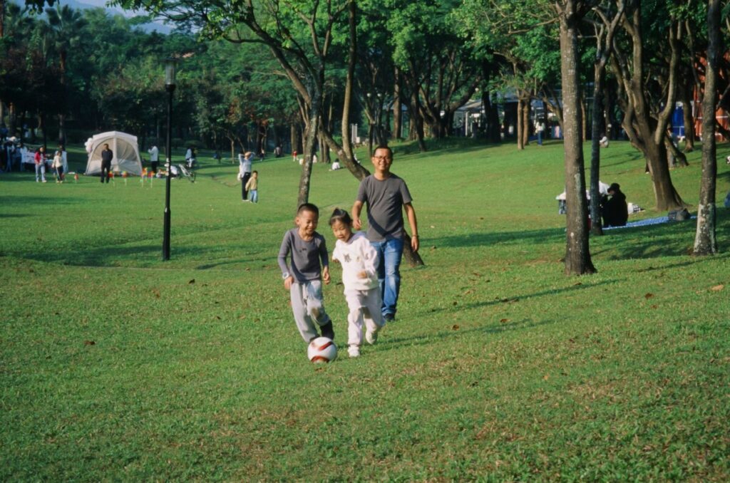 육아기 근로시간 단축 급여 지원을 통해 경제적 걱정 없이 아이와 함께하는 일상-부모와 아이들이 함께 하는 모습으로 제도를 통해 지켜지는 소중한 일상과 정부 지원 혜택의 연결고리를 상징합니다.