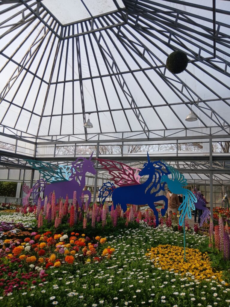 벚꽃뿐만 아니라 다채로운 봄꽃이 가득한 2026 인천대공원 벚꽃 축제 현장.-인천대공원 온실 내부에 조성된 화려한 화단과 유니콘 조형물입니다. 2026 인천대공원 벚꽃 축제는 벚꽃뿐만 아니라 튜립, 무스카리 등 다양한 봄꽃을 함께 감상할 수 있는 종합 꽃 축제입니다.