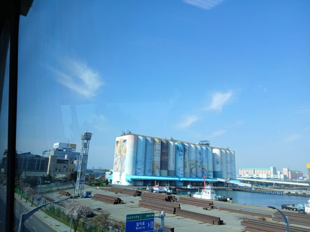인천 월미바다열차에서 내려다본 세계 최대 규모 사일로 벽화와 인천항 풍경-인천 월미바다열차 벚꽃 코스의 명물인 사일로 벽화입니다. 거대한 책들이 꽂혀 있는 듯한 이색적인 풍경이 봄날의 정취를 더해줍니다.