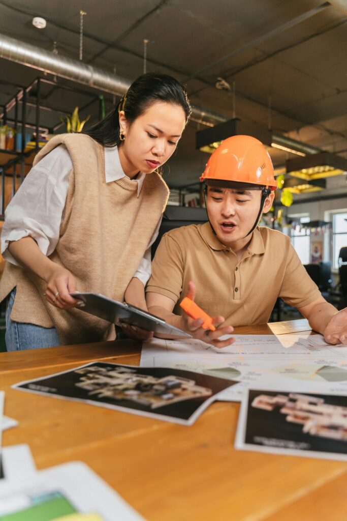 2026 근로자의 날 수당 총정리 : 사무실에서 도면을 보며 진지하게 대화하는 남녀 근로자의 모습