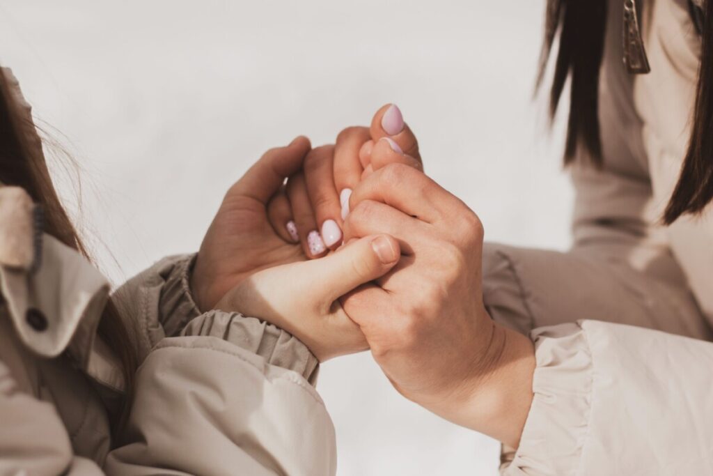 진심 어린 마음으로 어머니가 아이 손을 잡고 교감하는 사진으로, 학기 말 지친 아이의 감정을 온전히 받아주는 깊이 있는 자녀 대화법을 상징합니다.