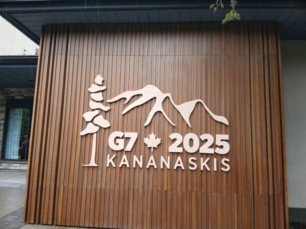 캐나다 로키 여행 길목에 위치한 2025년 G7 정상회의 개최지 카나나스키스 우드 사인보드－반프 국립공원으로 향하는 여정 중 들른 유명 휴양지 카나나스키스(Kananaskis) 리조트 벽면에 멋스럽게 새겨진 G7 2025 공식 로고와 나무 벽면.